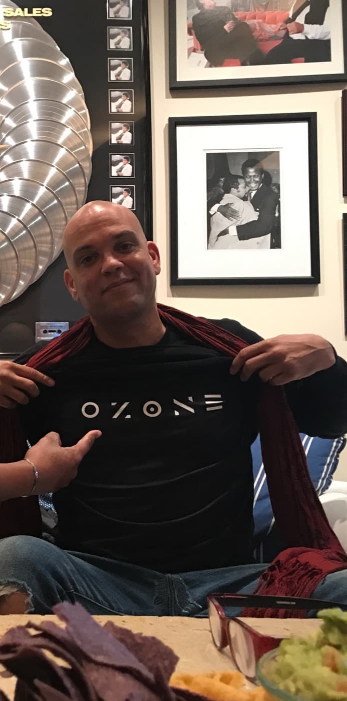 Quincy Jones III showing the OZONE logo on his shirt, with the Michael Jackson platinum records behind him, at Quincy Jones's home in Bel Air