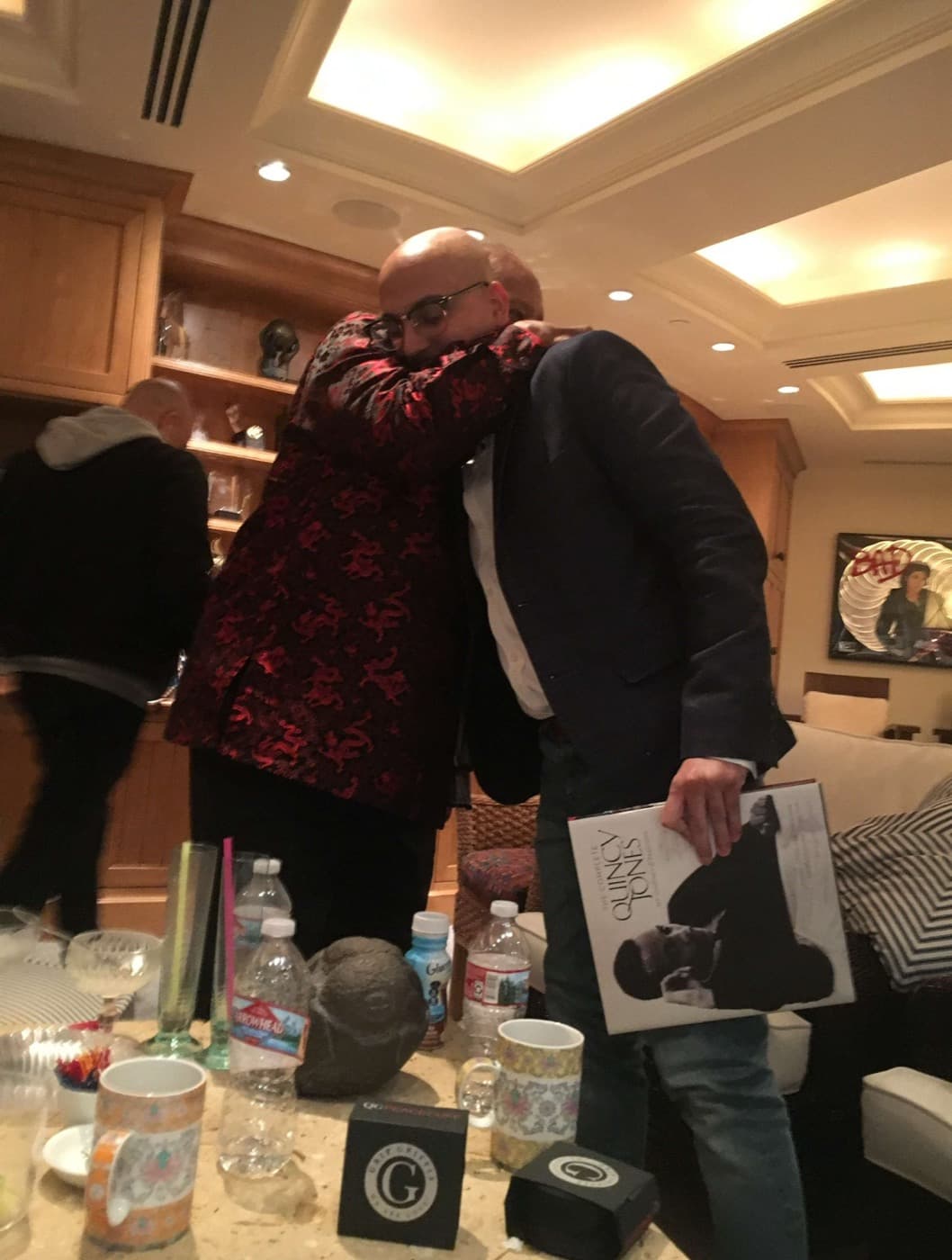 Anik Devaughn embracing Quincy Jones, who is holding the signed copy of The Complete Quincy Jones, at his 85th birthday, Los Angeles, 14 March 2018